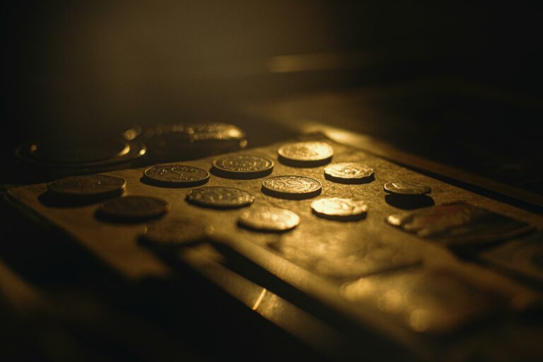 Close-up of vintage coins in warm lighting with artistic shallow focus.